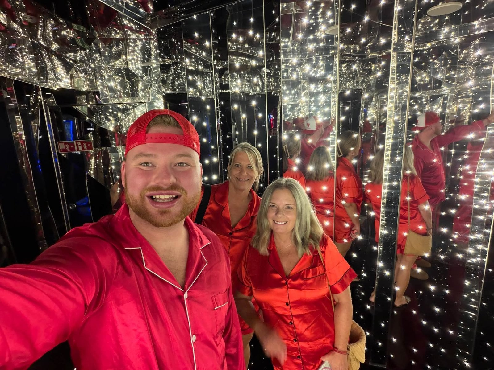 Logan White and family in matching red pajamas inside The Manor mirror hallway on PJ Night