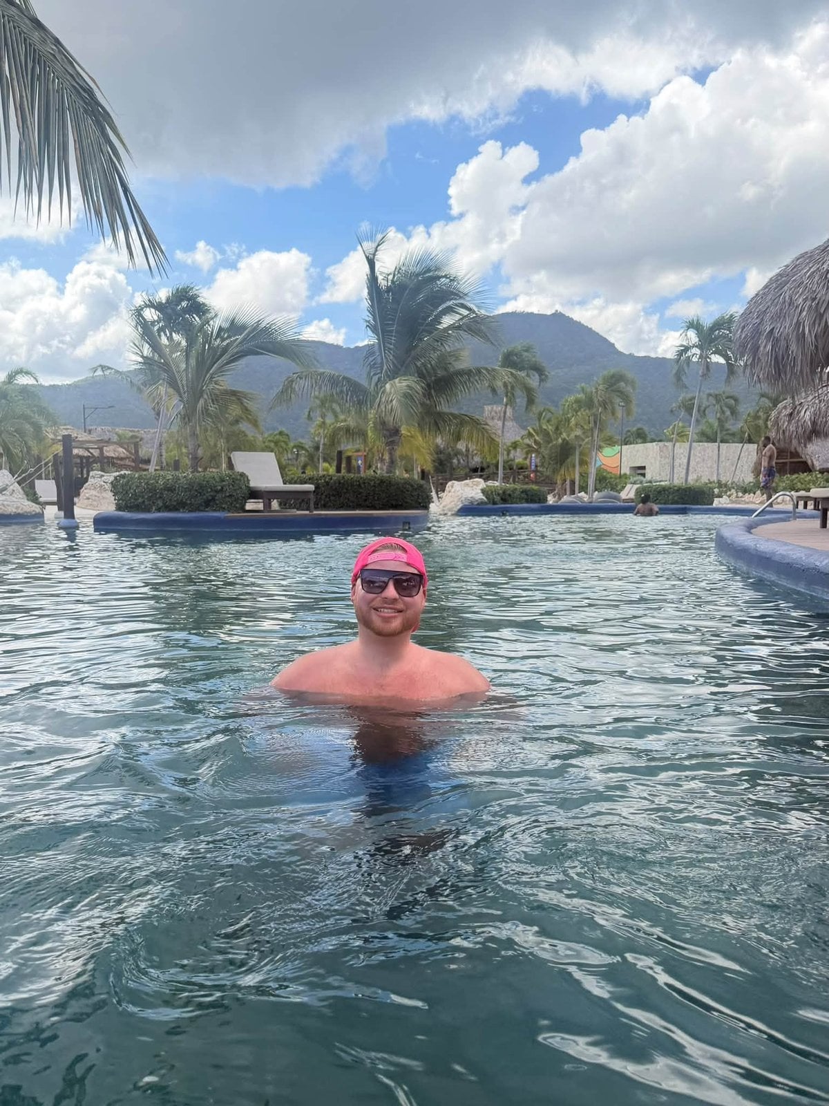 Relaxing in a tropical resort pool overlooking lush island mountains