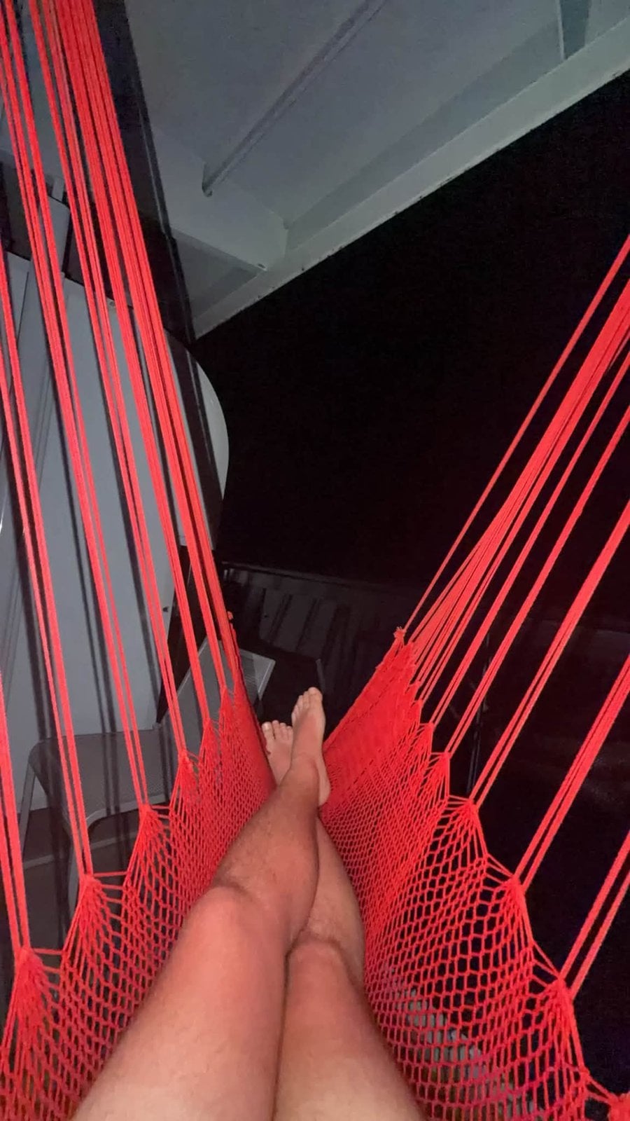 Relaxing inside the red balcony hammock on Virgin Voyages Scarlet Lady