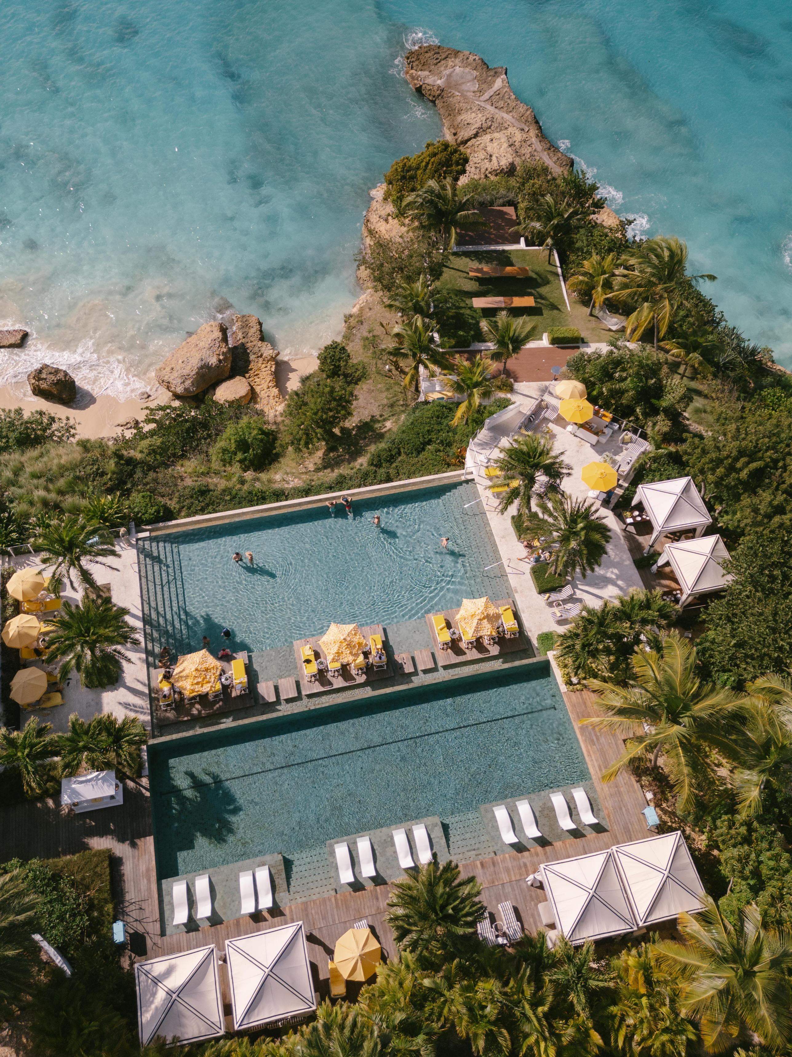 Cascading two-tiered cliffside infinity swimming pools at Malliouhana