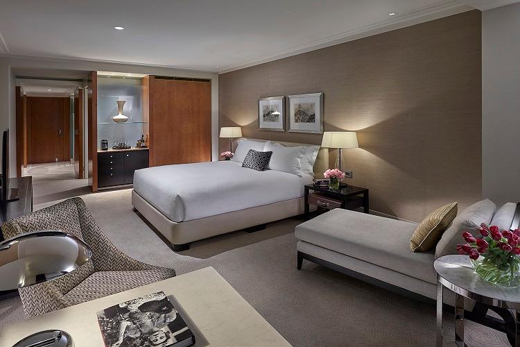 Deluxe King Room with custom furnishings, luxury bedding, and city streetscapes