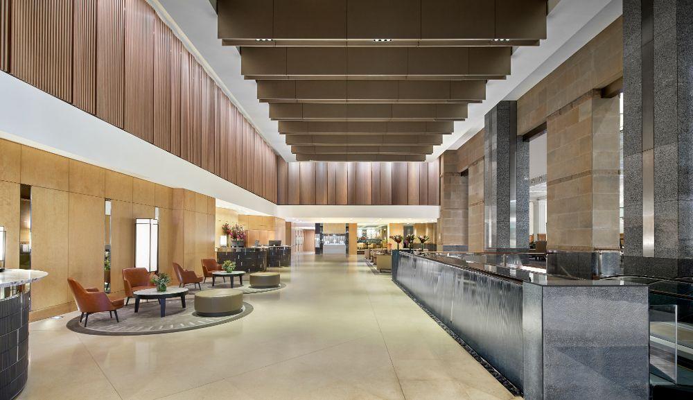 Sunlit glass atrium lobby combining sandstone with contemporary design