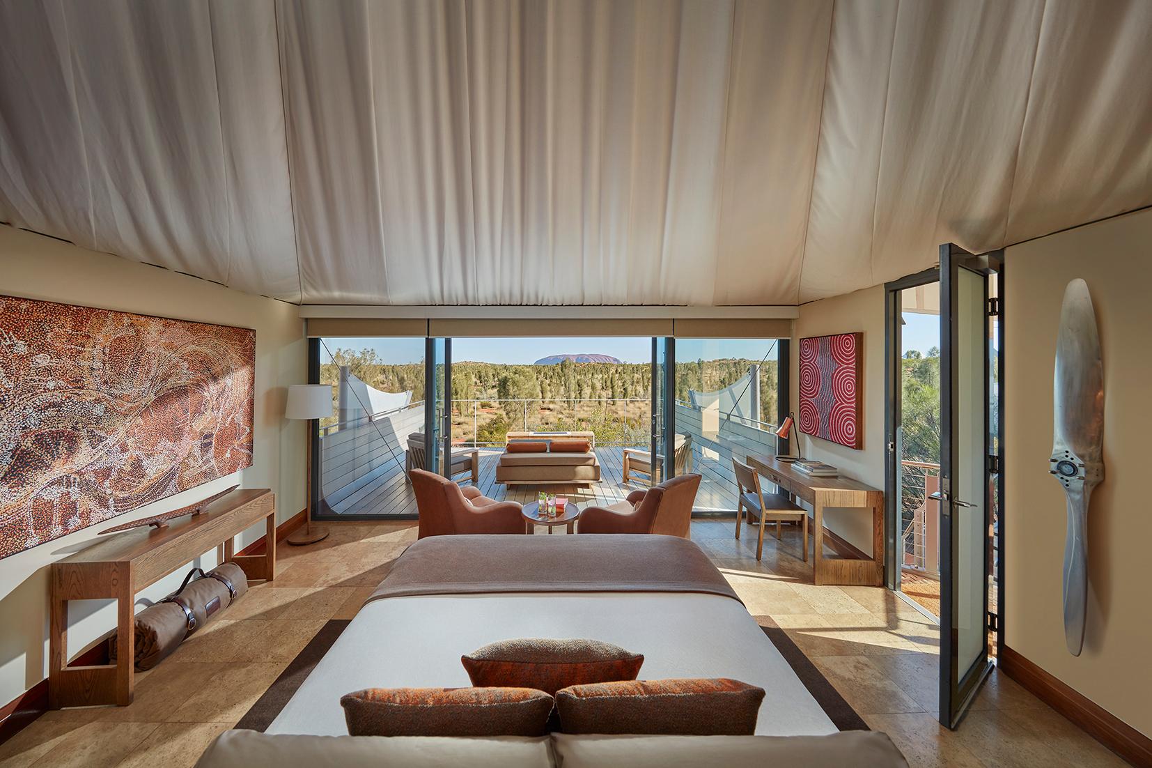 Luxury Tent interior with floor-to-ceiling glass framing views of Uluru