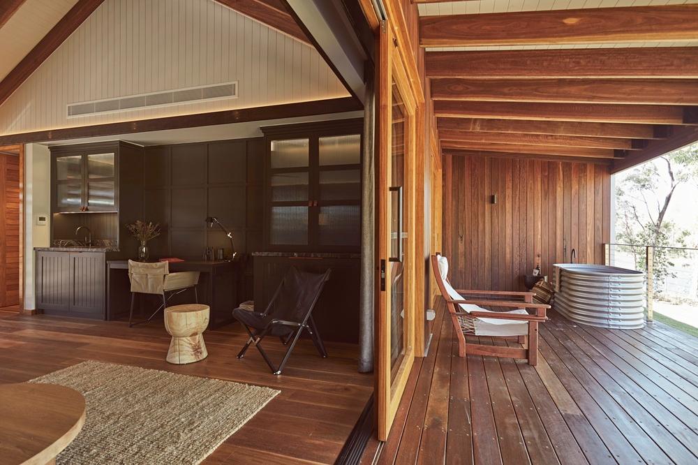 Interior of Outback Retreat suite with king bedding and reclaimed timber fireplace