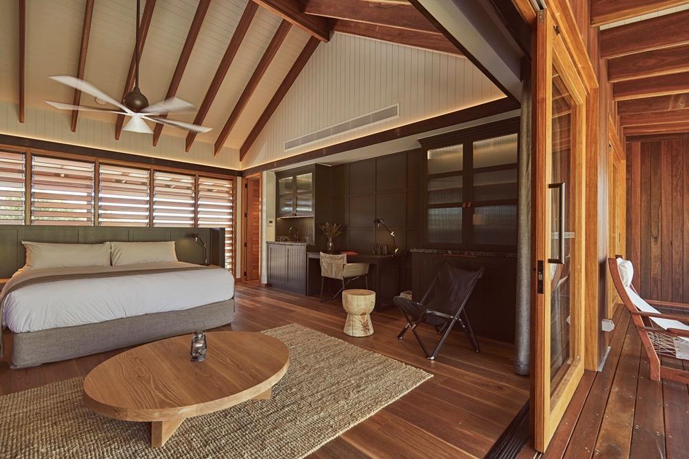 Deep corrugated iron outdoor soak tub on private timber veranda framing weir views