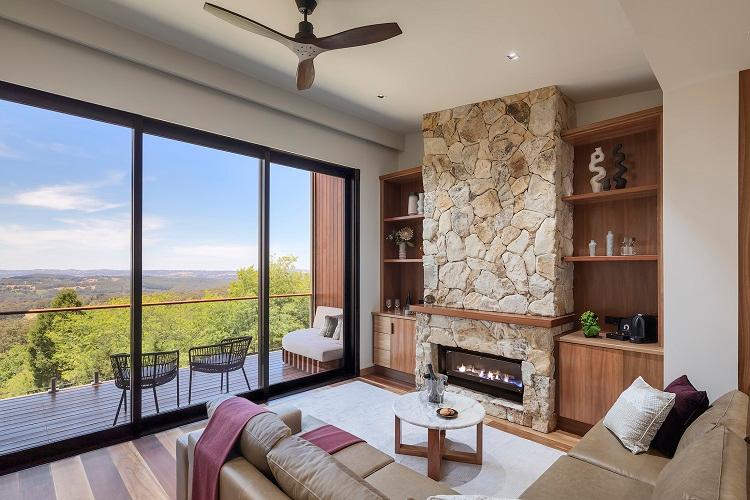 Sequoia open-plan suite interior featuring sunken lounge, stone-clad gas fireplace, and valley views