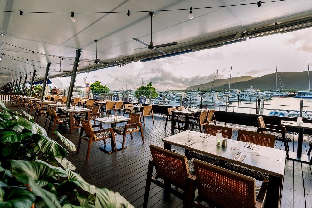 The Backyard Restaurant waterfront dining terrace overlooking Trinity Inlet and marina yachts