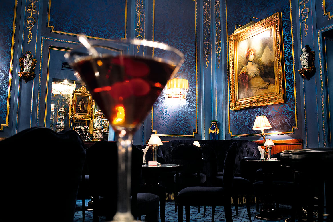 Blaue Bar with dark blue brocade walls and crystal chandeliers