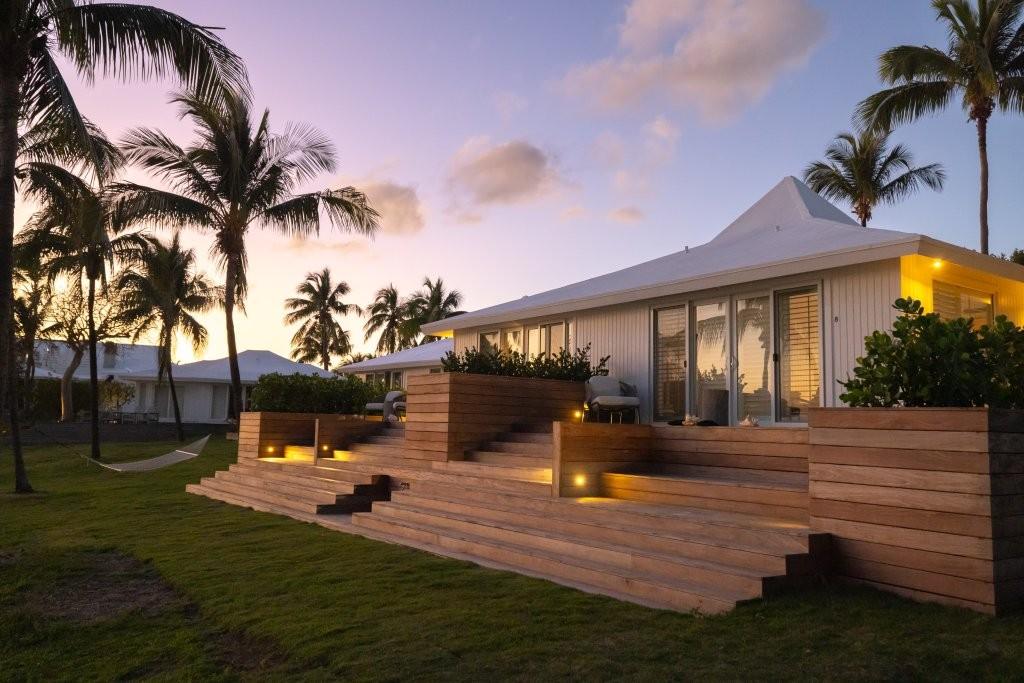 Private furnished porch of a beachfront suite overlooking the turquoise shallows