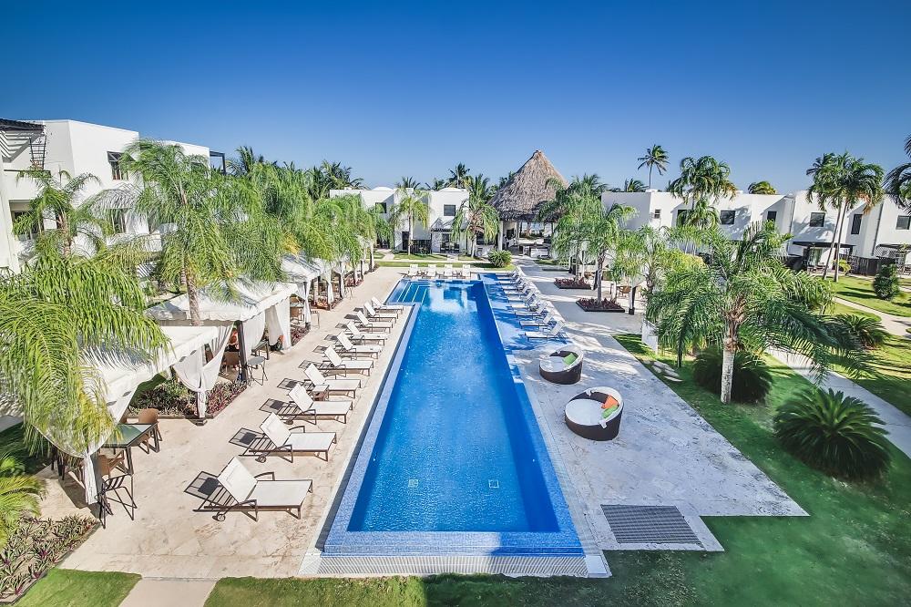 70-foot freshwater infinity swimming pool with comfortable sun loungers and coconut palms