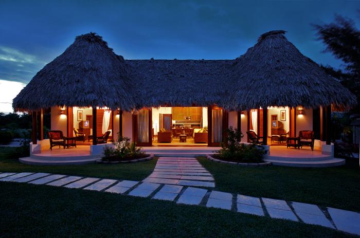 Luxury Thatched Roof Villa master suite featuring plantation furnishings and rich hardwoods