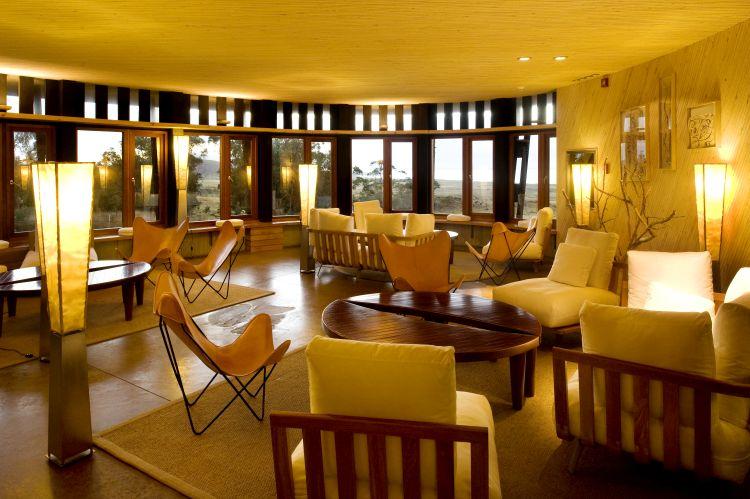 Dining room and lounge with glass-walled kitchen at Explora Rapa Nui