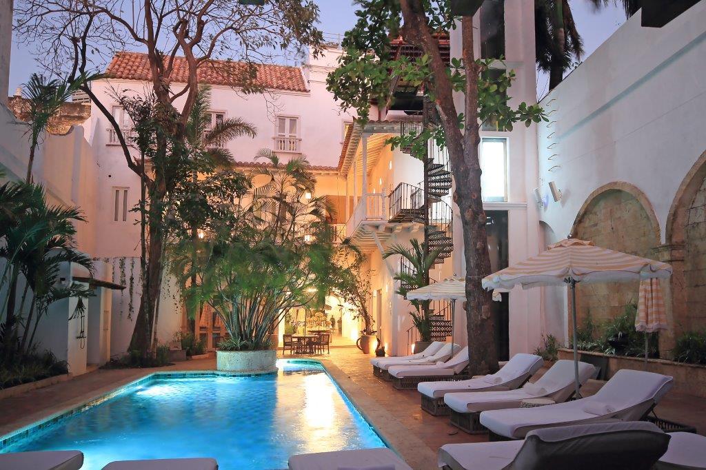 Lush internal courtyard swimming pool surrounded by Moorish arches and tropical palms