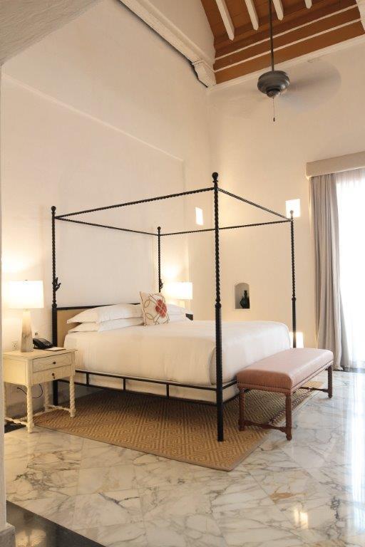 Suite de Madariaga master bedroom featuring original 18th-century colonial frescoes and soaring ceilings