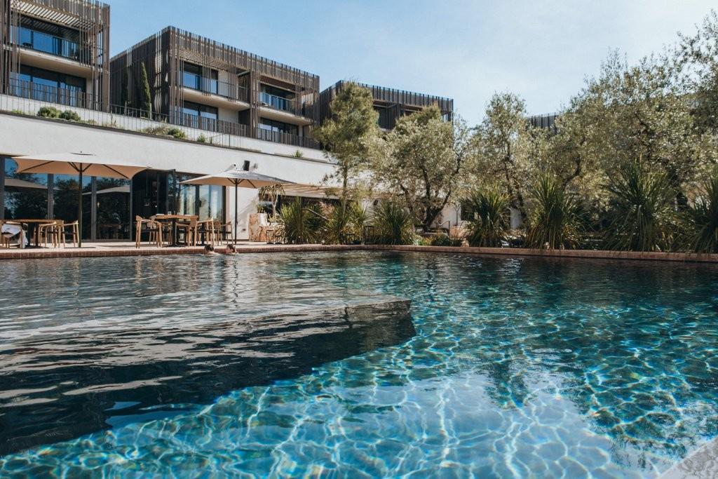 Heated outdoor swimming pool surrounded by olive trees