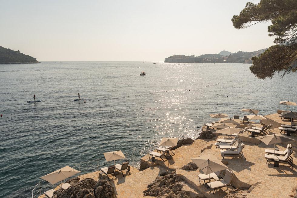 Private cliffside beach platform with teak sunbeds