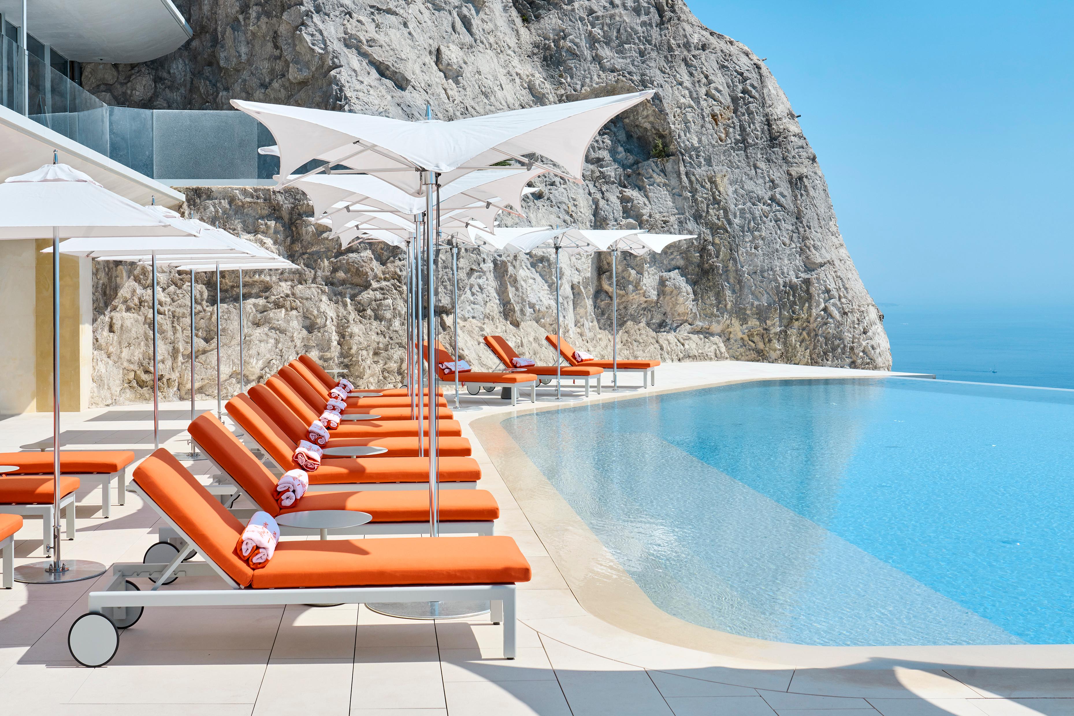 Heated Cliffside Infinity Pool Merging with Azure Sea