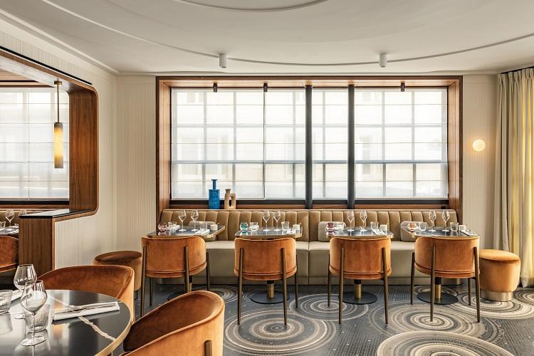 Les Parisiens chic dining room with leather banquettes and mirrors