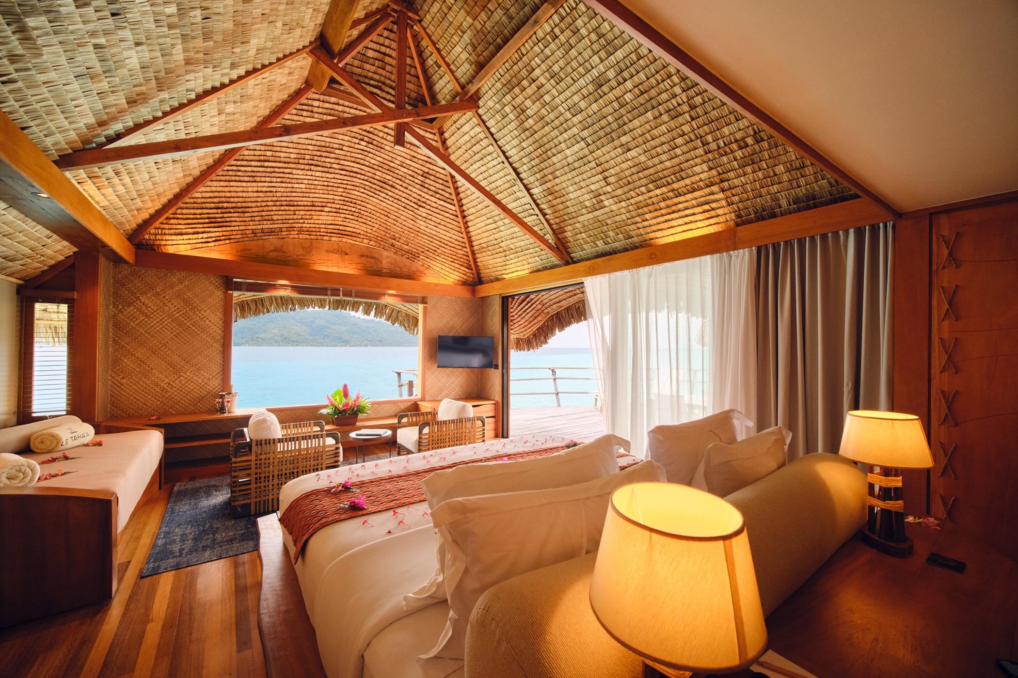 Traditional thatched Polynesian Overwater Suite above crystalline turquoise waters