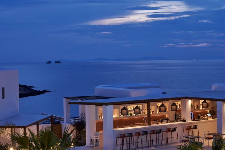 Main tiered swimming pool surrounded by luxury daybeds and Aegean sunset views