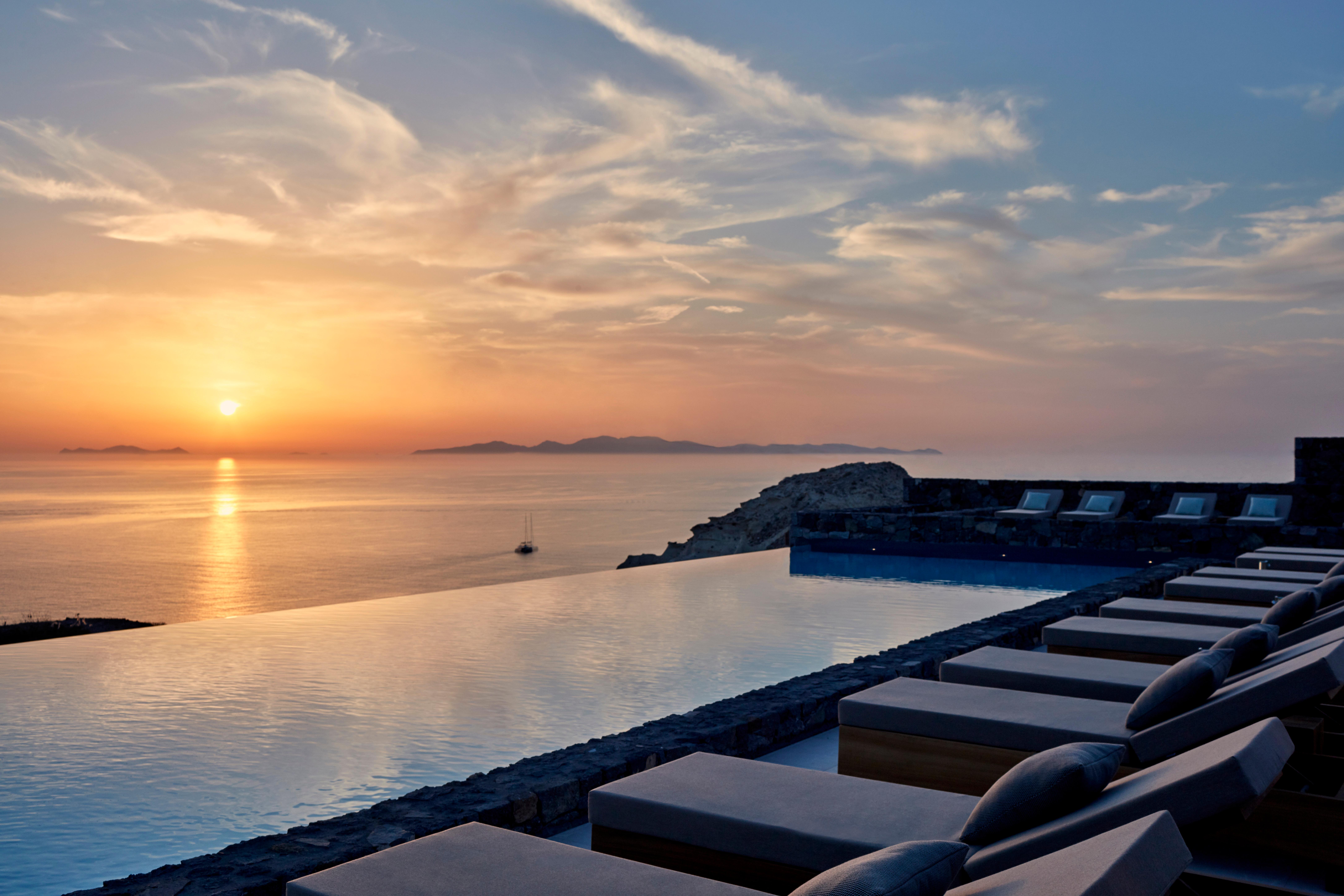 Canaves Epitome infinity pool and sunset over Ammoudi Bay in Oia Santorini
