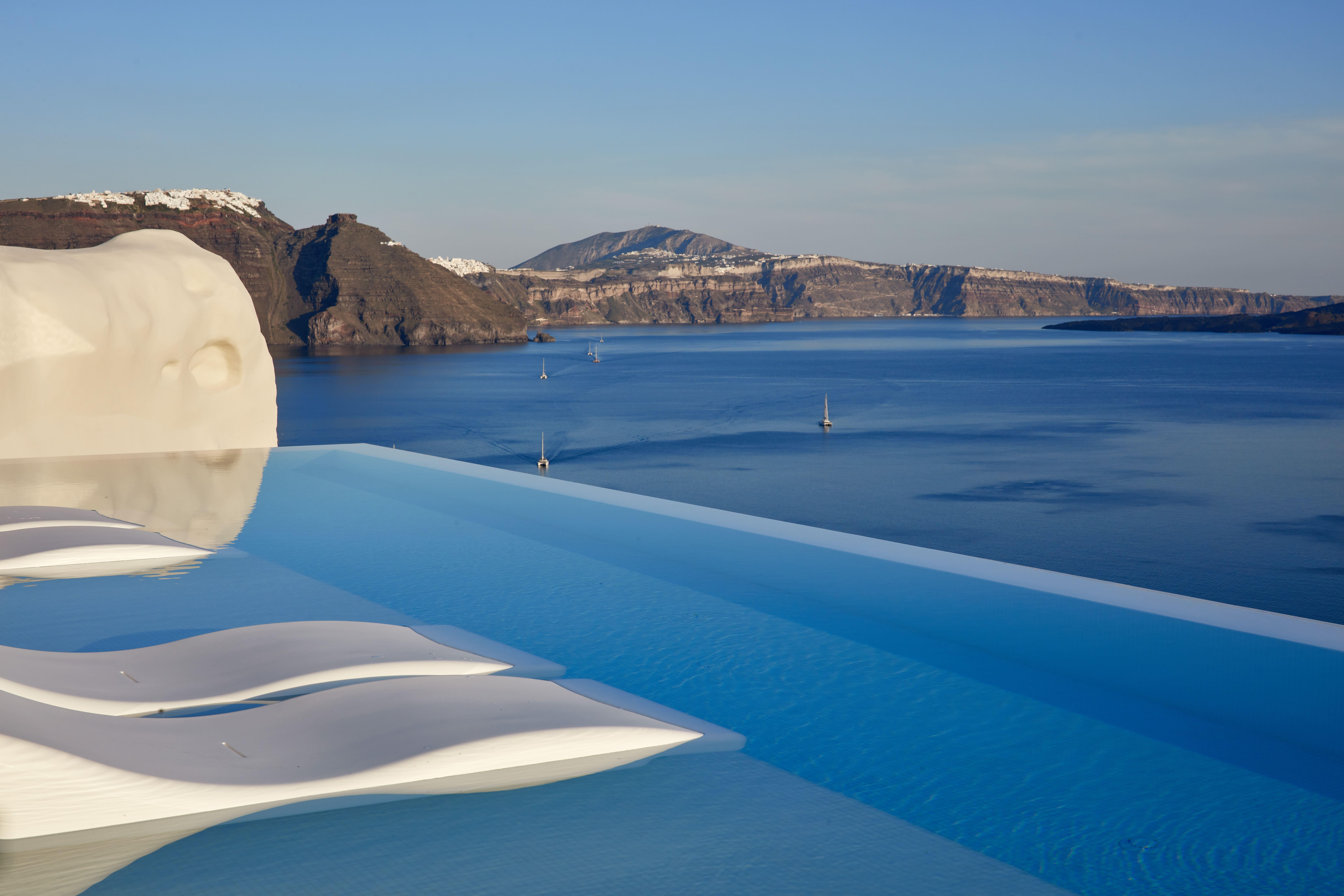Canaves Oia Suites multi-tiered cliffside infinity pool overlooking the Santorini caldera