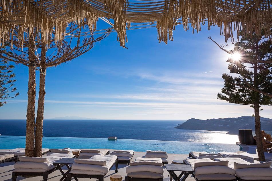 Myconian Utopia Clifftop Infinity Pool with Floating Sunbeds Overlooking Elia Beach
