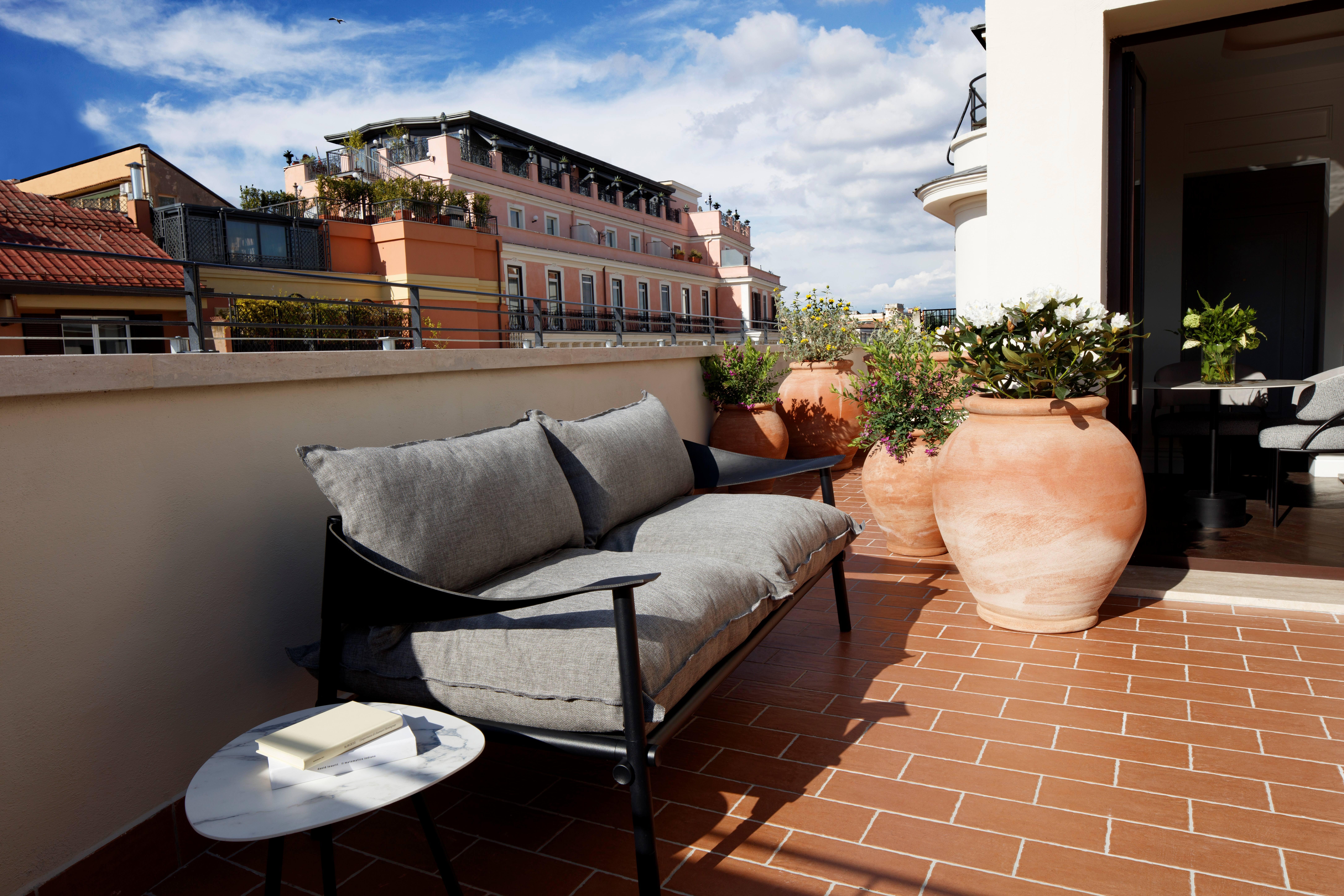 Rooftop terrace overlooking the historic roofs, cupolas, and cypress trees of Rome