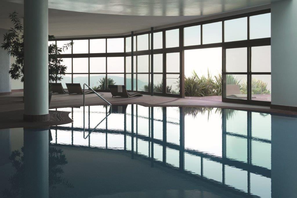 Heated indoor-outdoor thermal salt-water pool connecting to lake gardens
