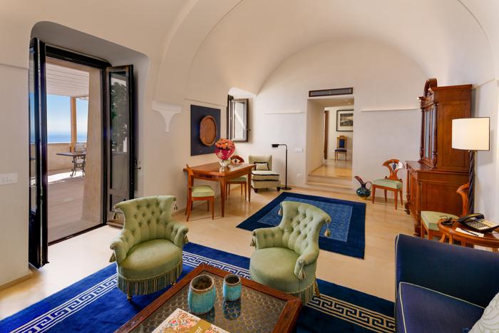 Luxury suite interior with antique fireplace and panoramic ocean views