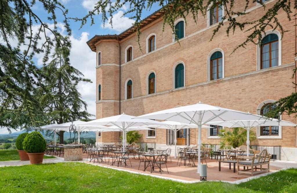 La Via Della Seta outdoor dining terrace surrounded by manicured Tuscan gardens and olive groves