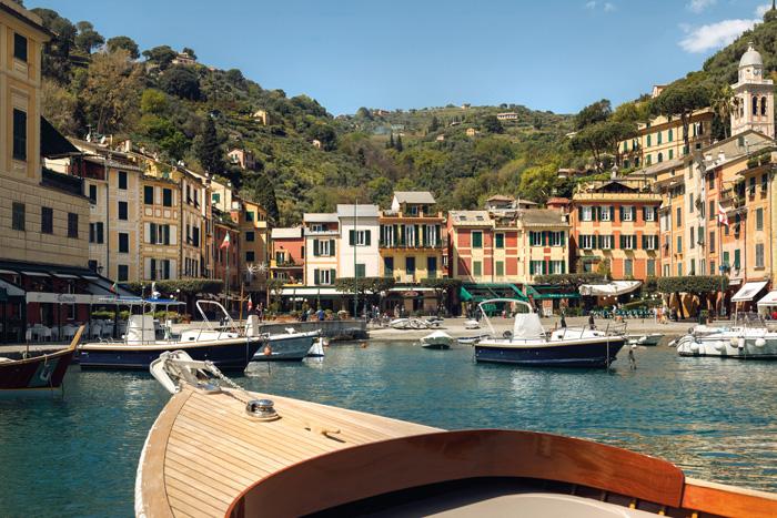 Guests cruising on a traditional wooden gozzo boat along Portofino promontory
