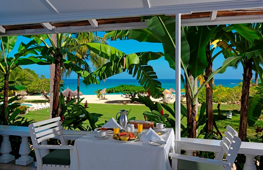 Jamaica Inn Deluxe Verandah Suite outdoor living room overlooking manicured lawn and private beach