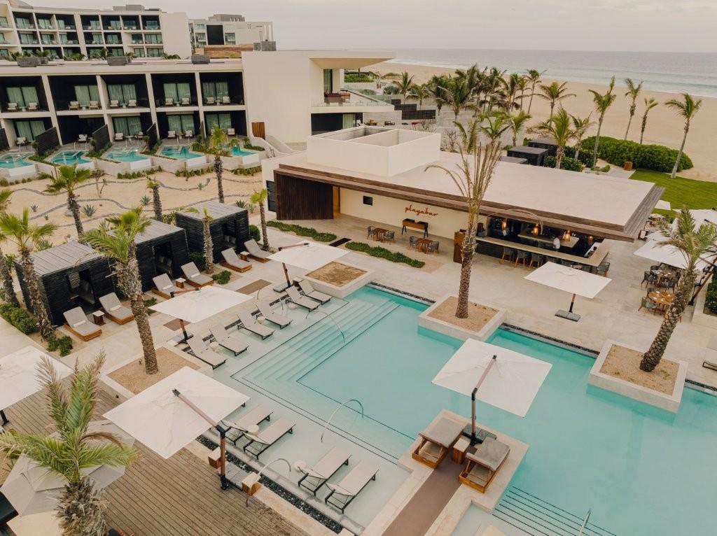 Cortez swimming pool lined with luxury daybeds, cabanas, and desert palms
