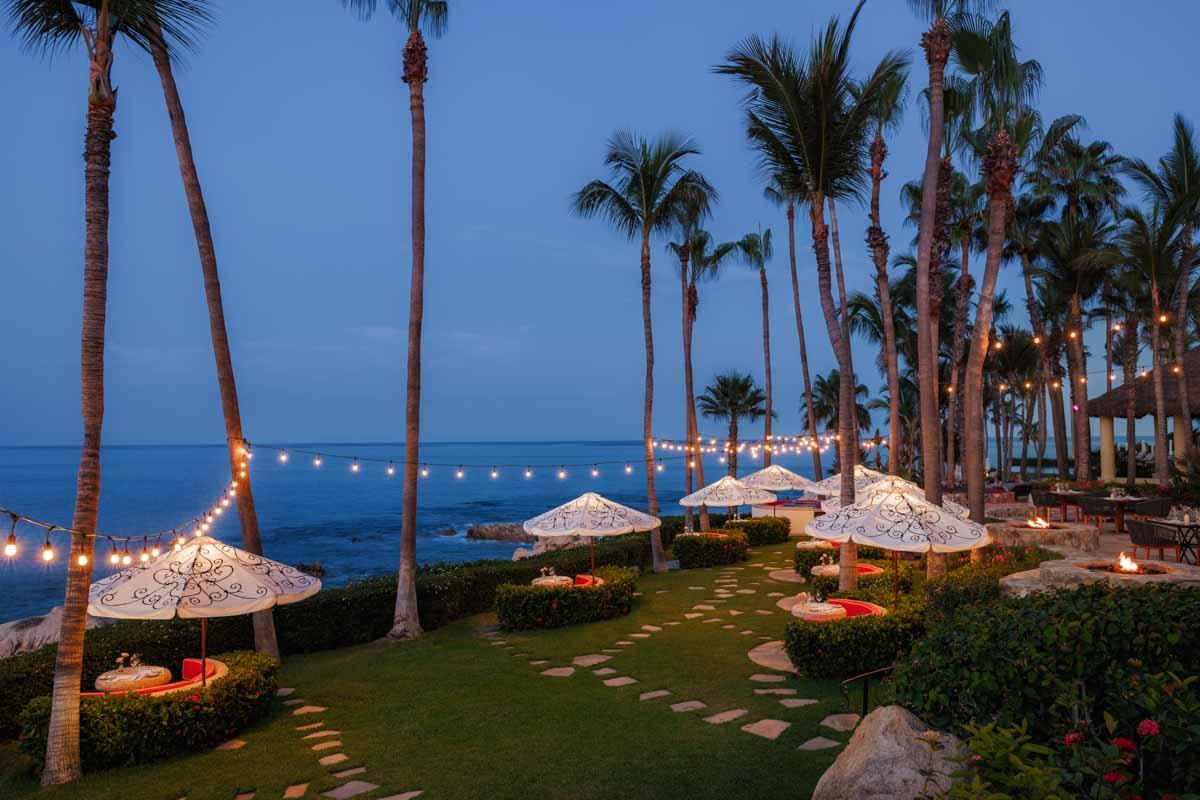 Agua restaurant open-air cliffside garden dining tables glowing at twilight