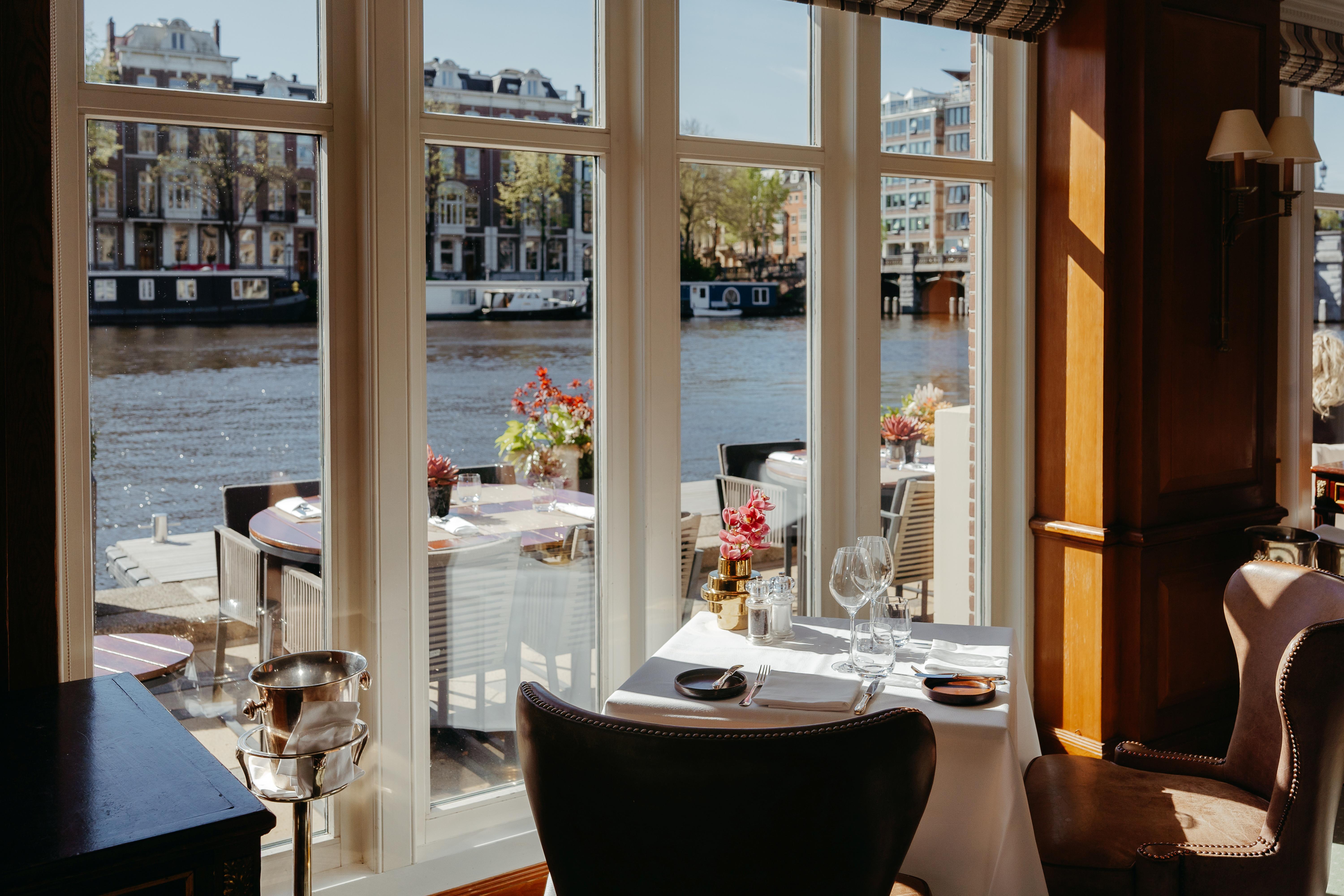 Fine dining salon of Amstel Restaurant overlooking the water with contemporary Dutch culinary touches