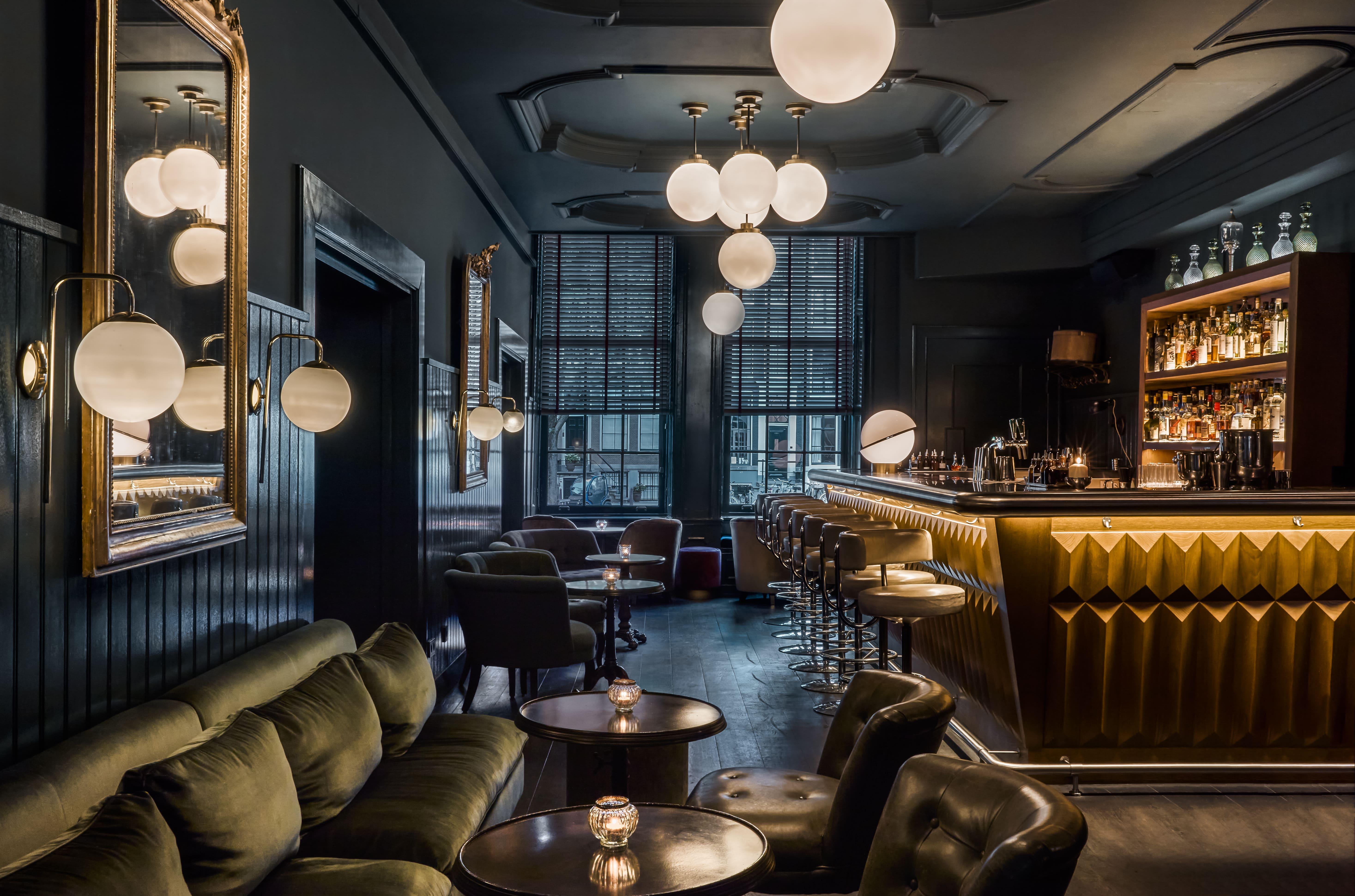 Award-winning Pulitzer's Bar with plush leather club chairs, dark wood panelling, and bespoke cocktails