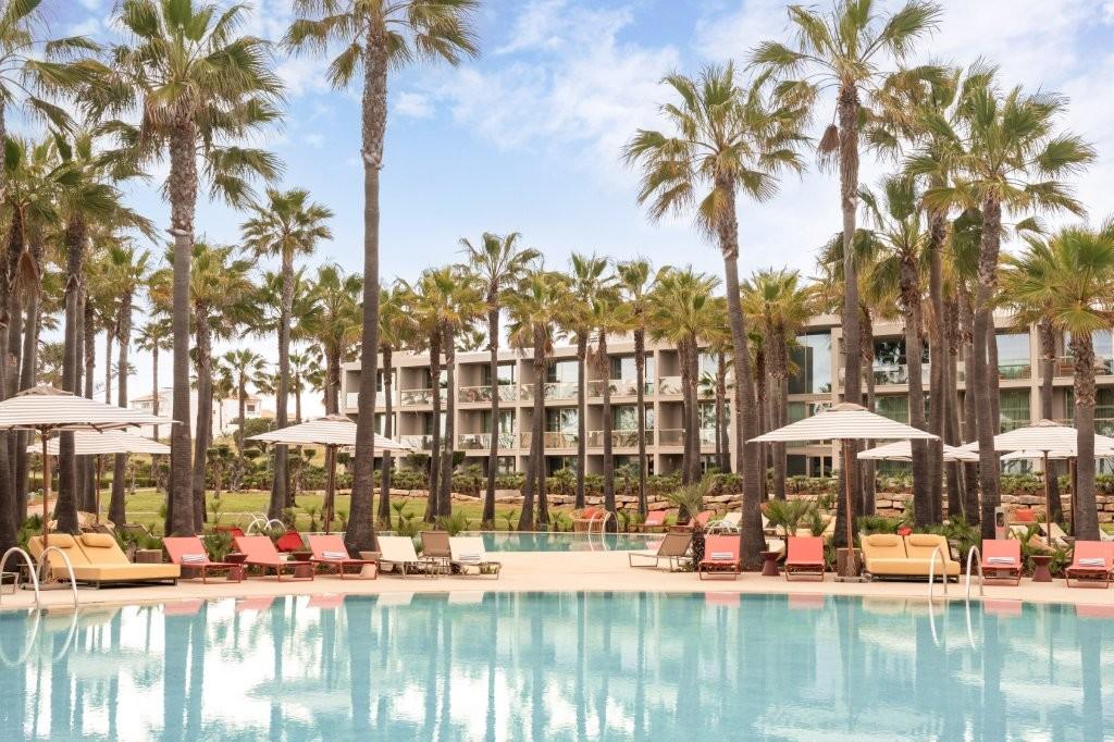 Lagoon Swimming Pool with Sun Loungers and Palms