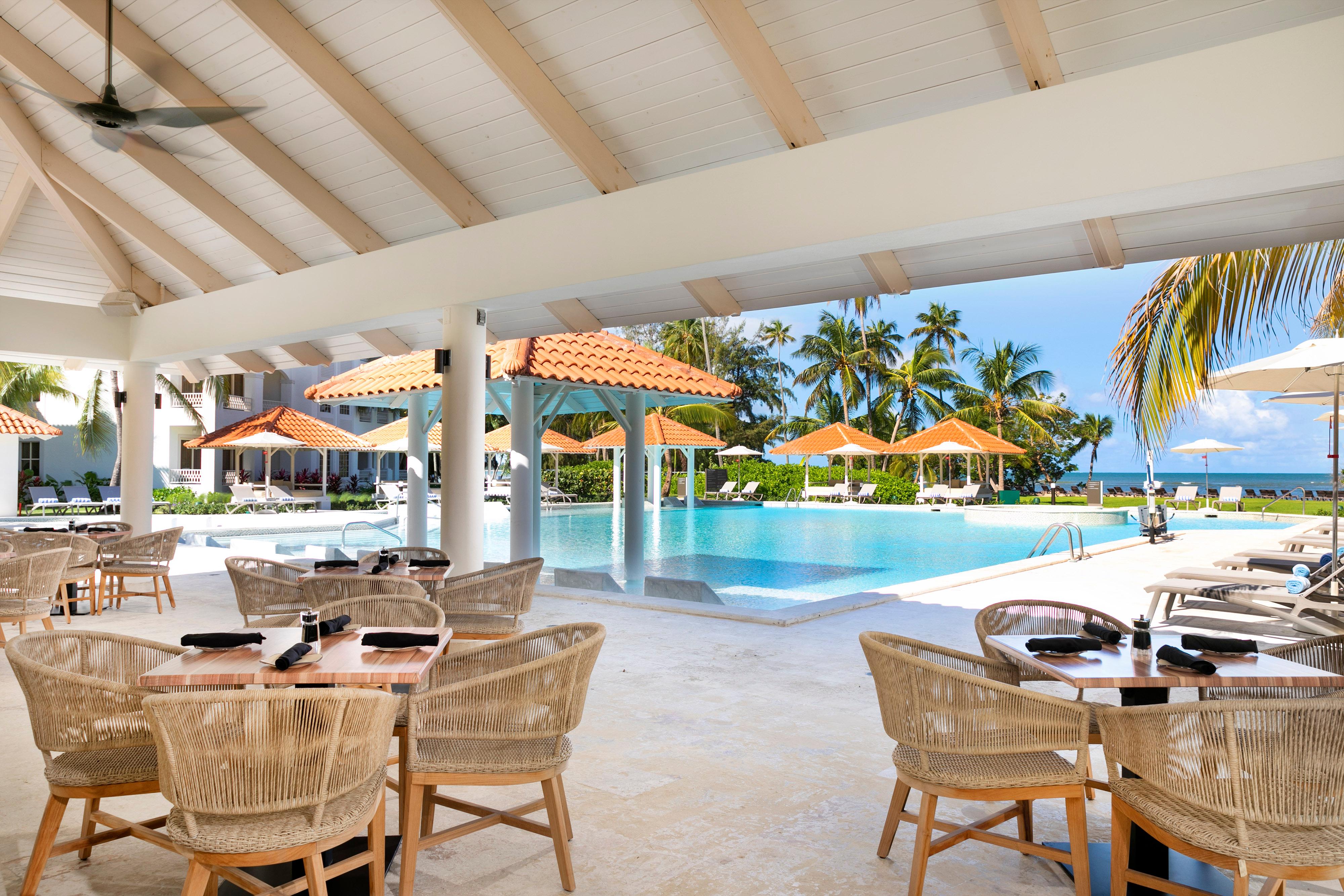 La Mina sprawling lagoon-style swimming pool with swim-up bar framed by swaying tropical palms