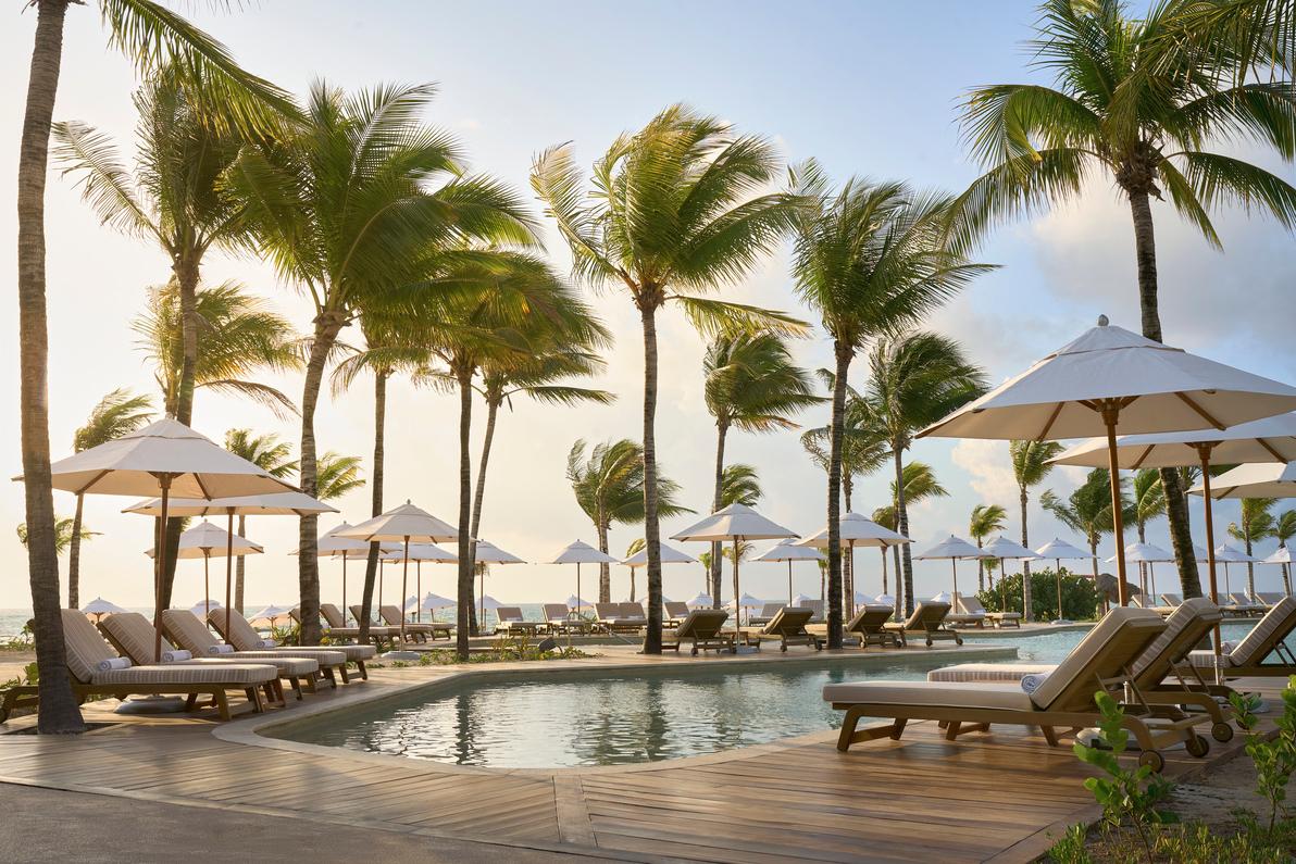 Oceanfront swimming pool with daybeds facing the turquoise sea