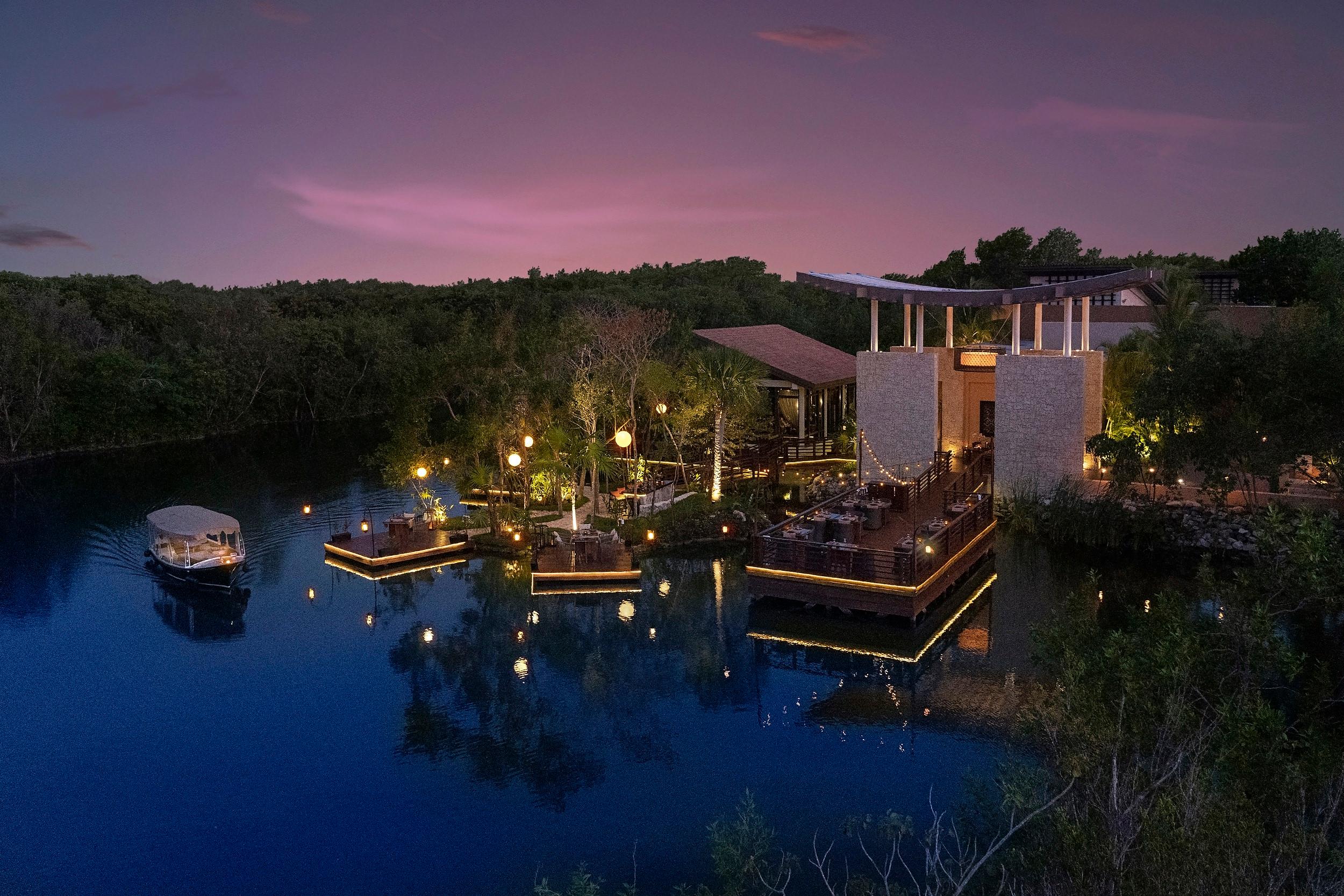 Saffron overwater Thai restaurant wooden pavilions illuminated over lagoon