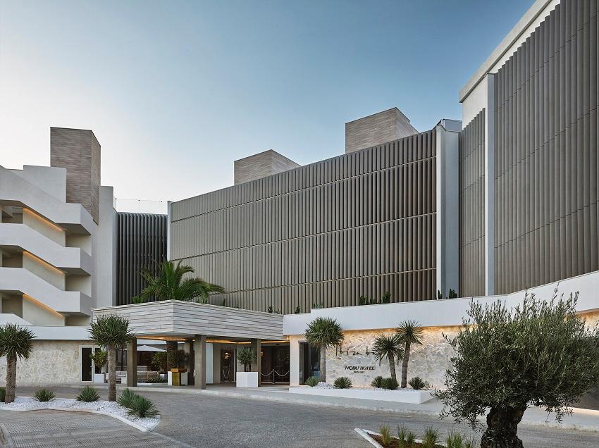 Chic whitewashed entrance and palm promenade of Nobu Hotel Ibiza Bay