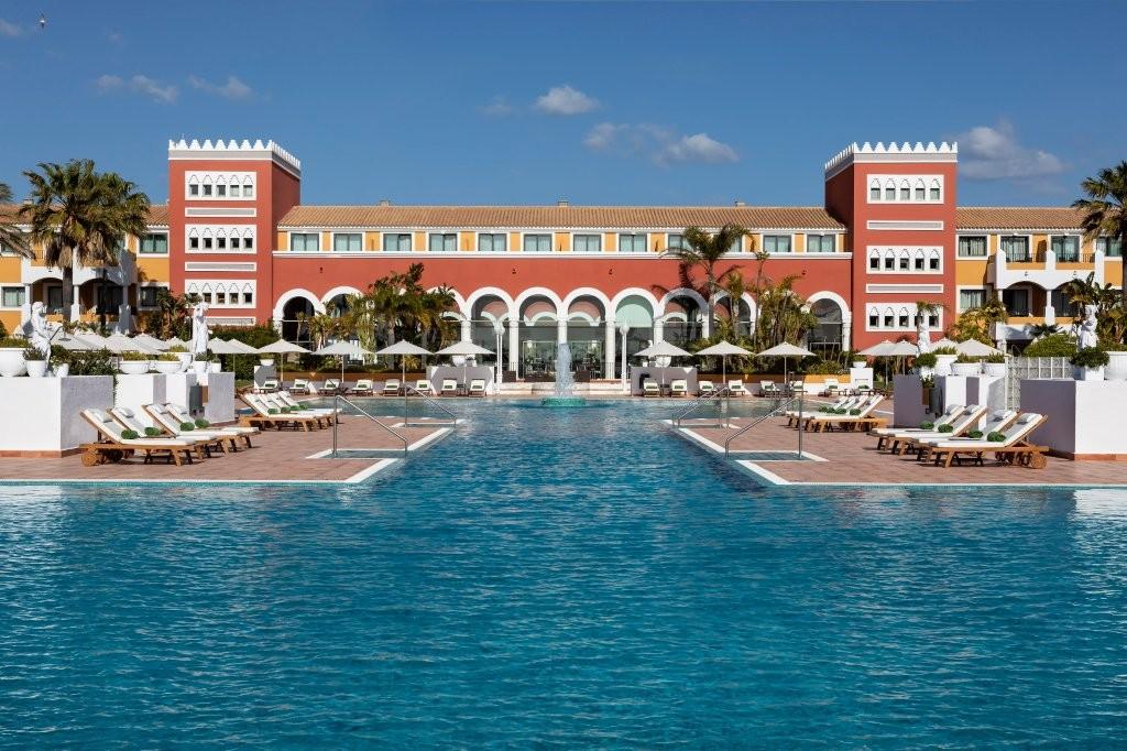 Resort lagoon swimming pool surrounded by tropical palm gardens
