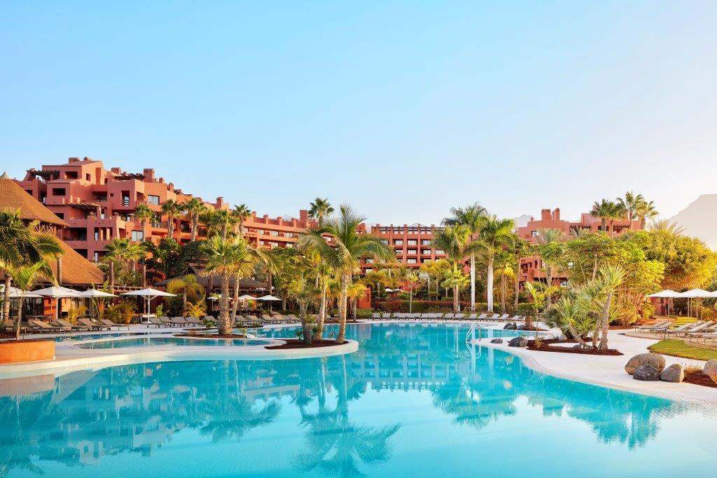 Heated saltwater swimming pools surrounded by palms and sun loungers