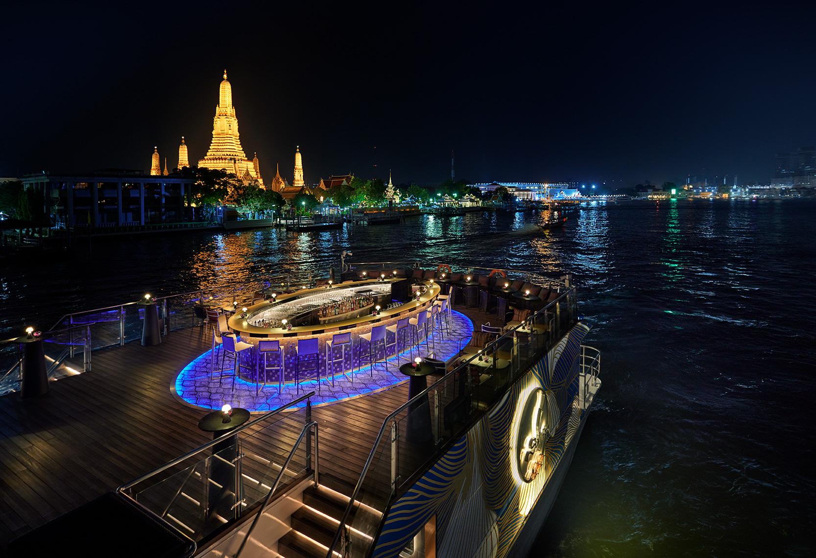 Saffron Cruise luxury dinner barge sailing the Chao Phraya River with illuminated temple views
