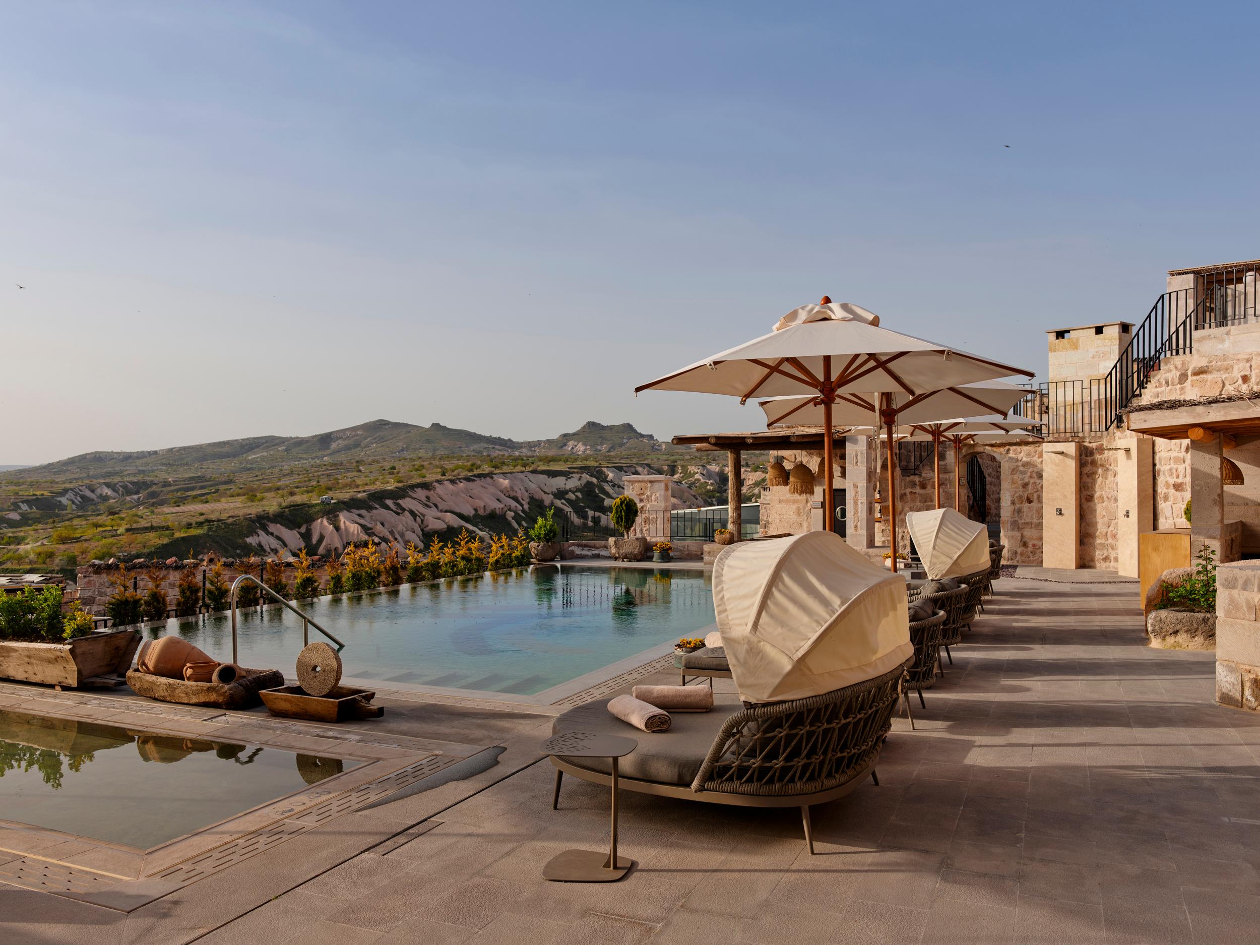 Outdoor heated swimming pool with panoramic views of fairy chimneys and Mount Erciyes