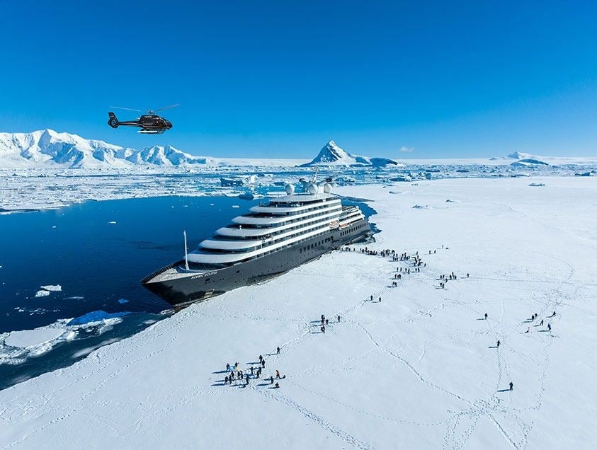 Scenic Eclipse 6-star discovery yacht sailing among towering blue glaciers in Antarctica