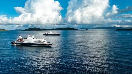 SeaDream Yacht Club twin mega-yacht anchored in a secluded Caribbean harbor