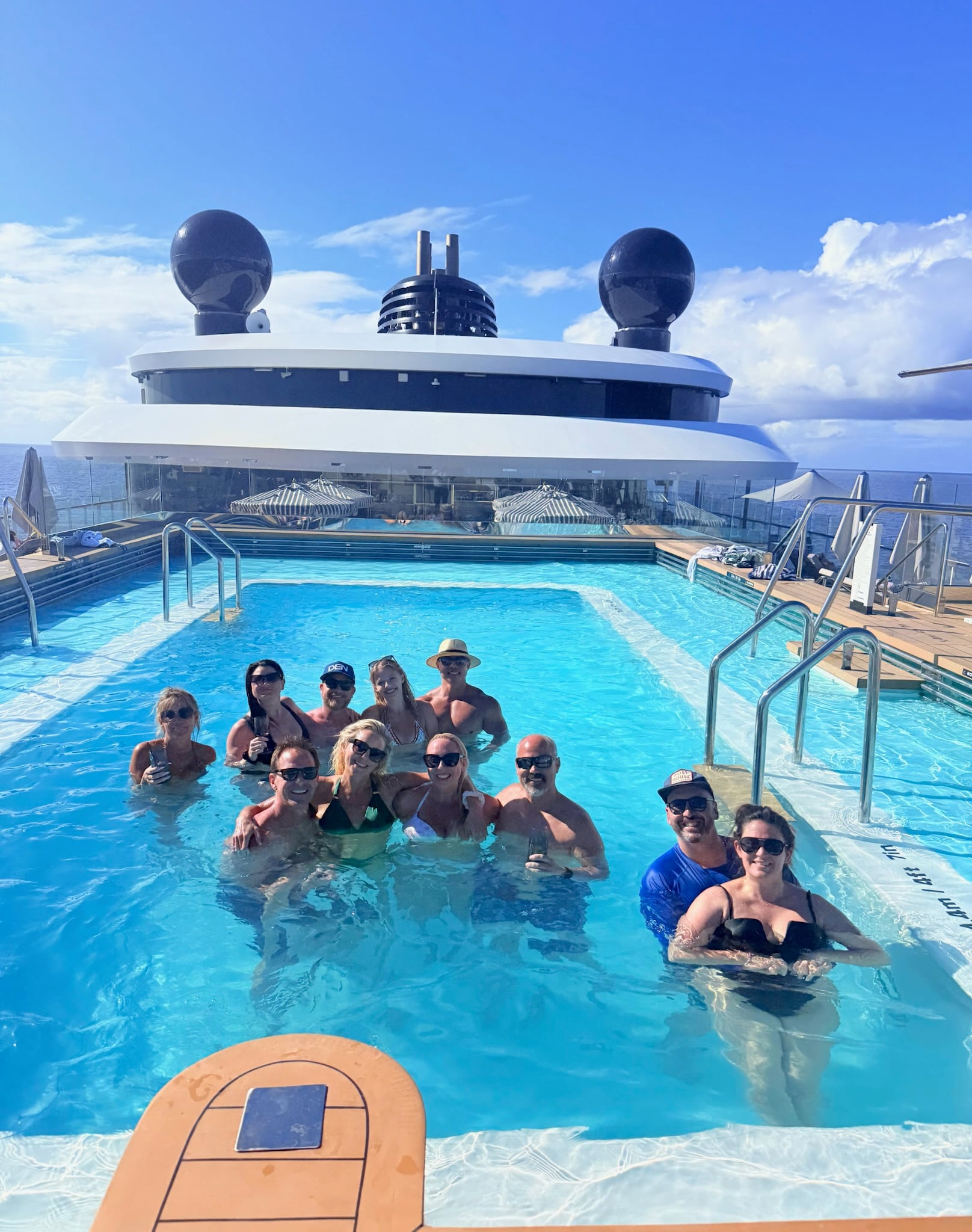 Group of friends having fun together in the infinity pool on Ilma