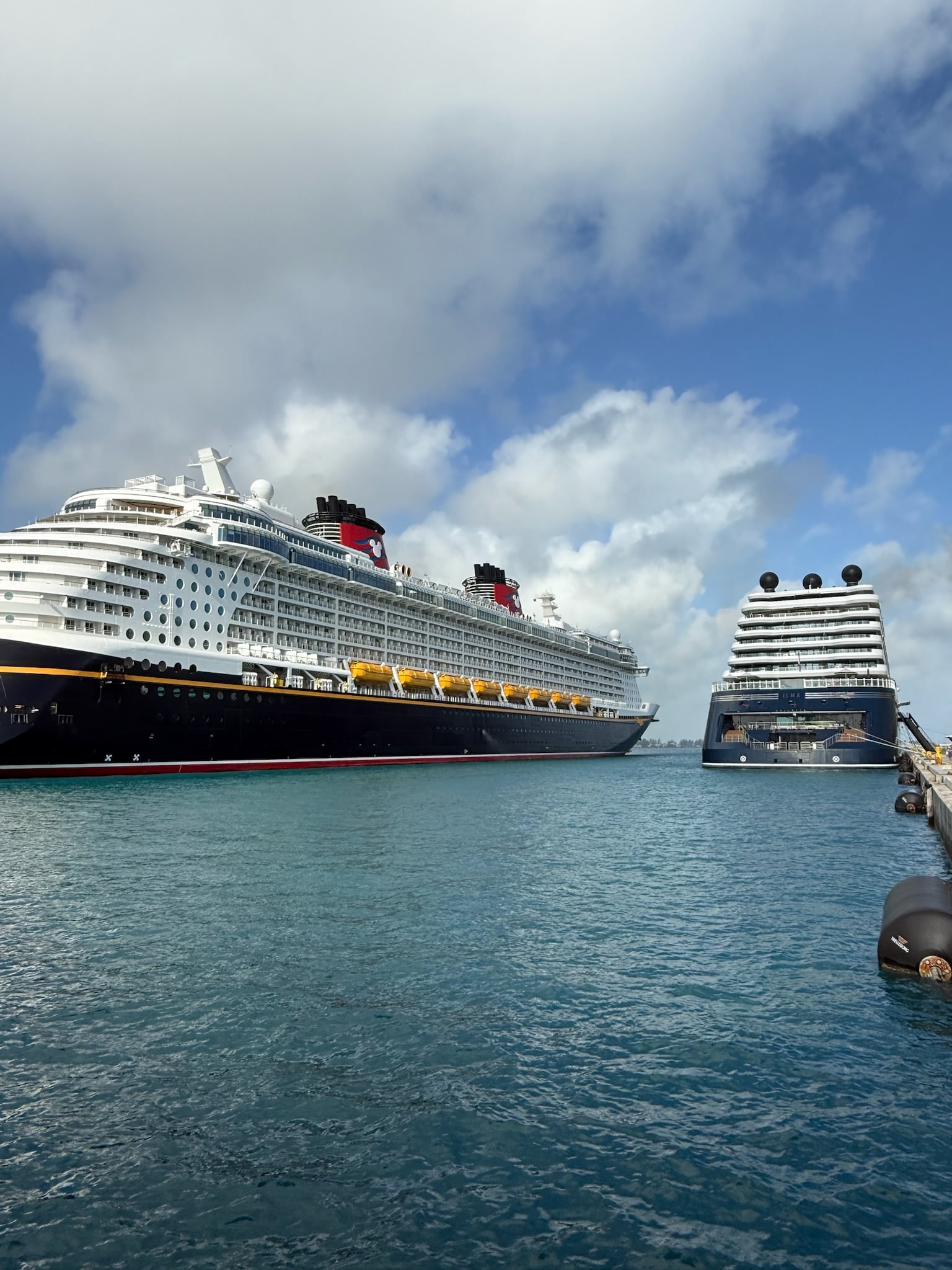 Ilma superyacht docked next to a massive cruise ship showing boutique scale